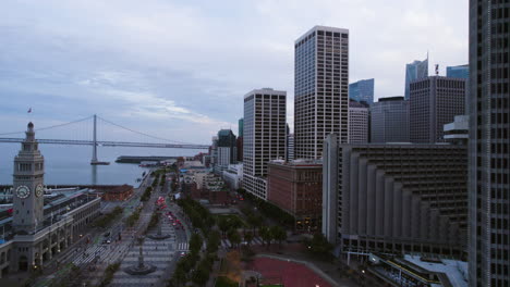 San-Francisco-Bayfront,-Aerial-View-of-Ferry-Building,-Embarcadero-and-One-Market-Plaza-After-Sunset,-California-USA