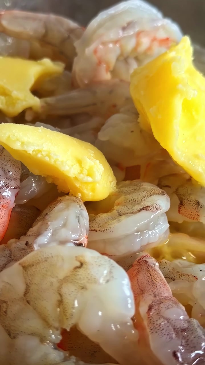 Raw shrimp with tails marinating in liquid with egg yolk, fresh seafood preparation before cooking, Latvia, extreme close up vertical shot