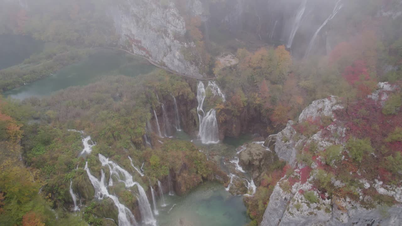 Cascata che fluisce dolcemente nella nebbia verso un lago sereno, Plitvice, Croazia