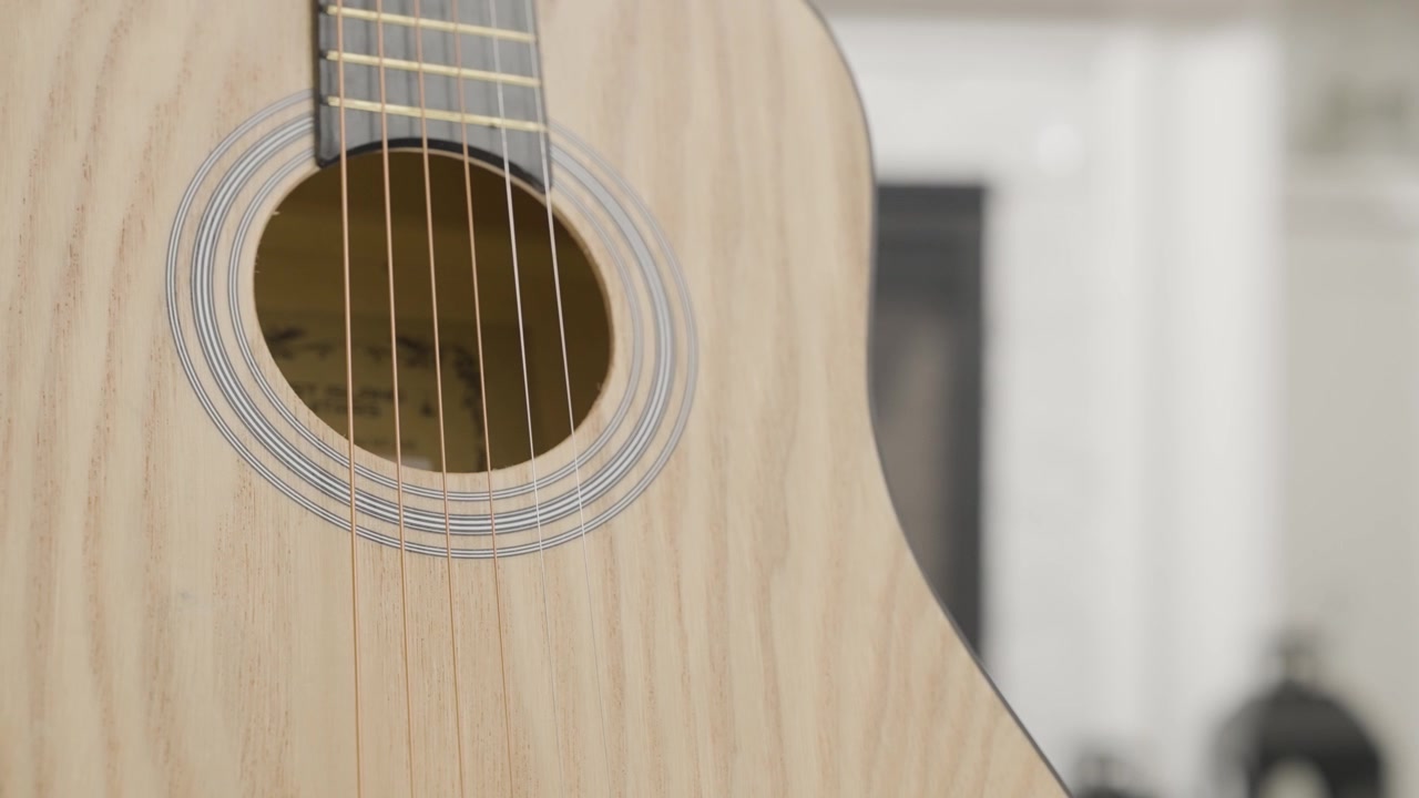 Bir evde akustik gitarın yakın çekimi.