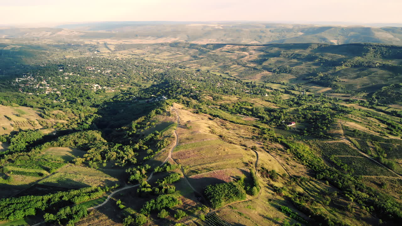 Aerial view of a lush green countryside with scattered villages and soft evening light