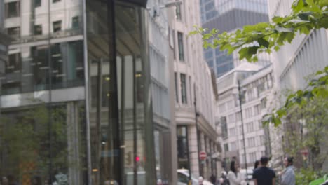 Muslim-Businesswoman-Talking-On-Mobile-Phone-Walking-Outside-Offices-In-City