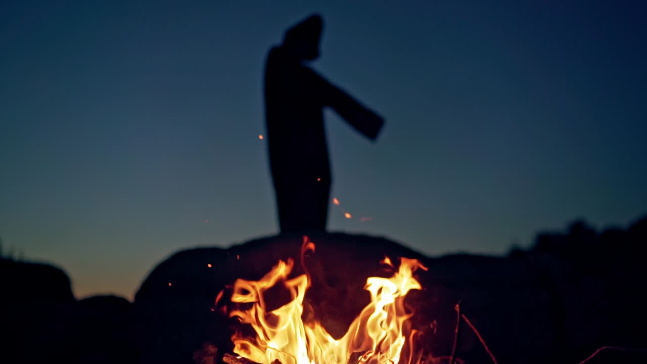 Witch by night fire in forest. Witch conjure by fire in night forest