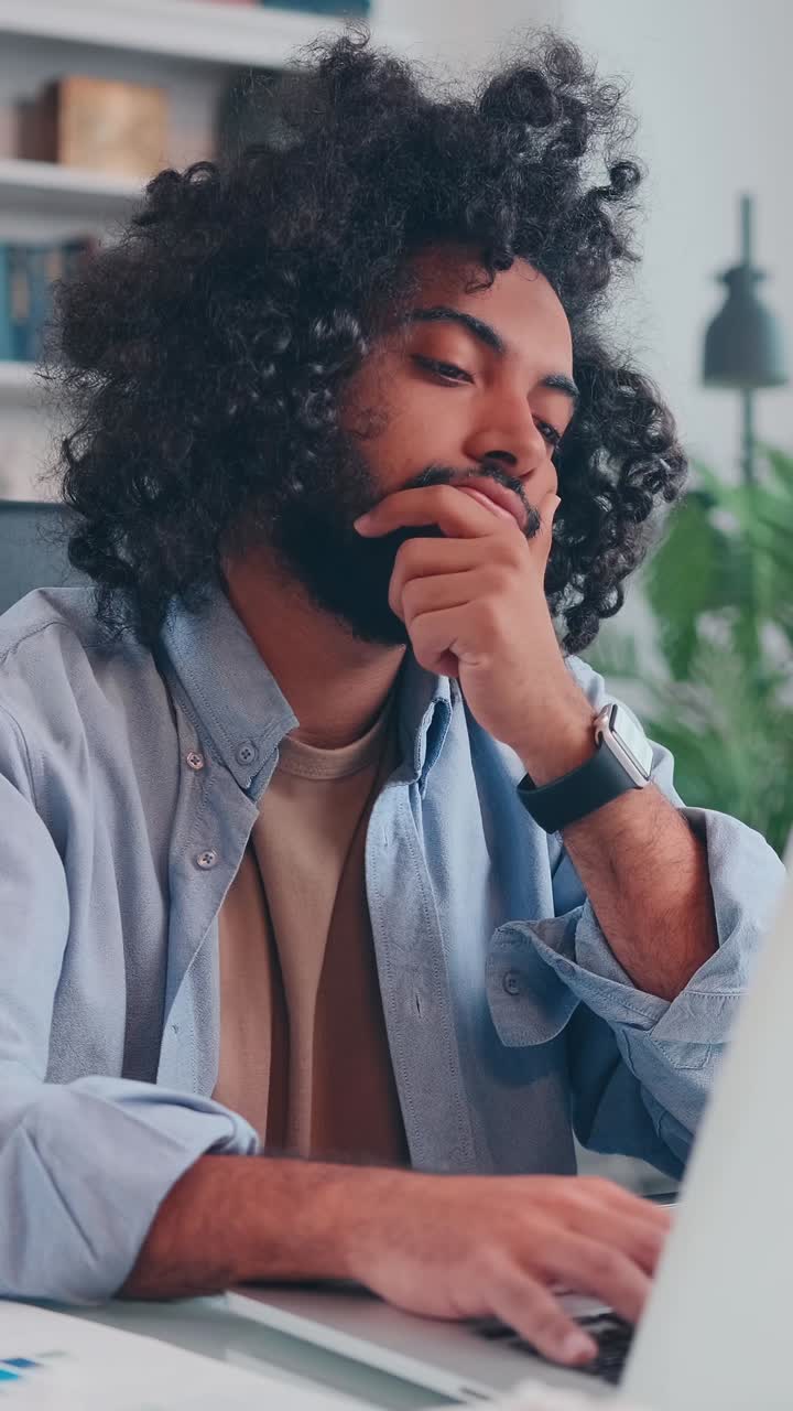 Young man struggles with stress while working on his laptop at home