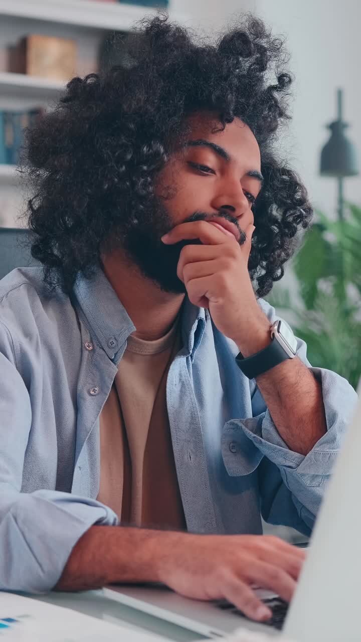 Young man struggles with stress while working on his laptop at home