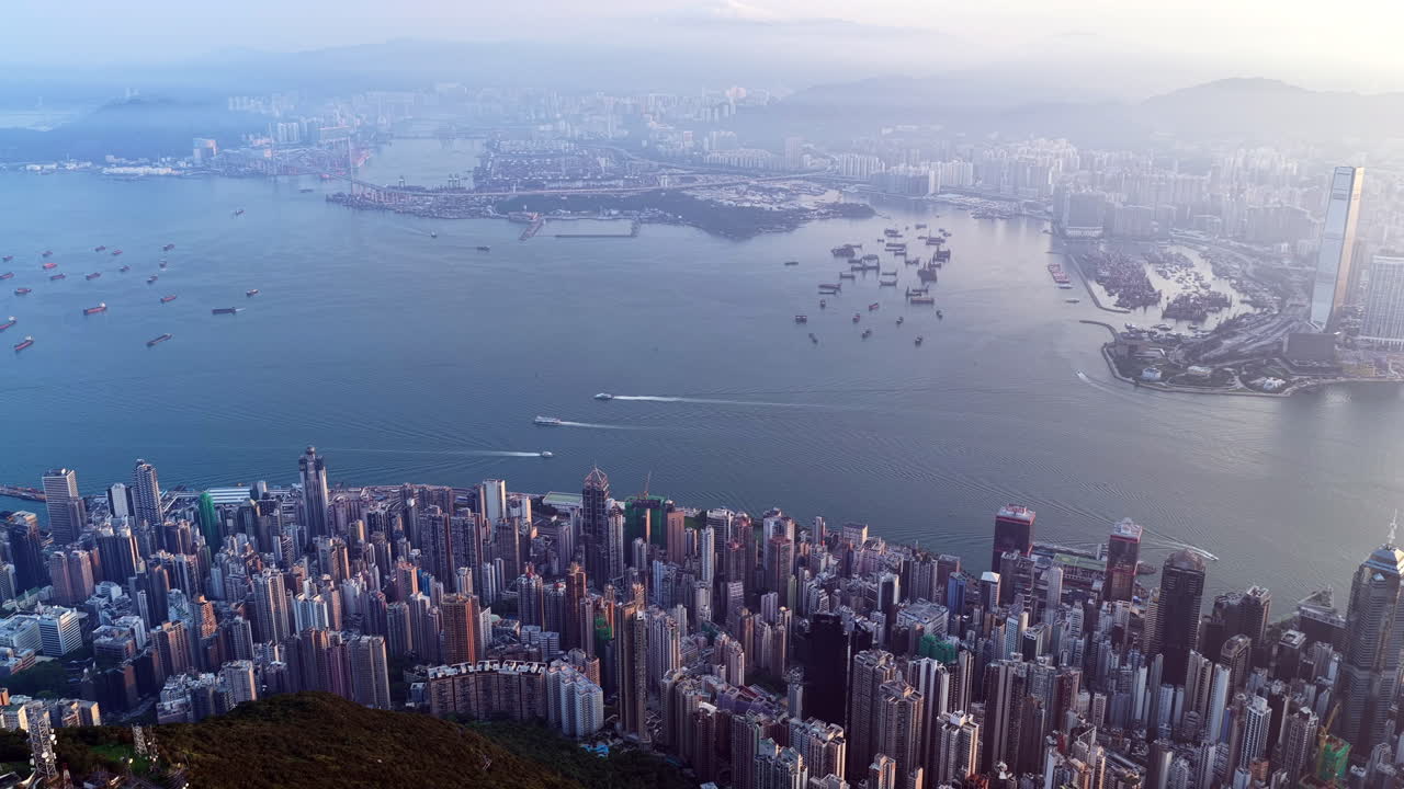 Cinematic aerial view of the Hong Kong skyline in morning light with cloud cover, showcasing the metropolitan city as a symbol of global finance, modern architecture, travel, and business