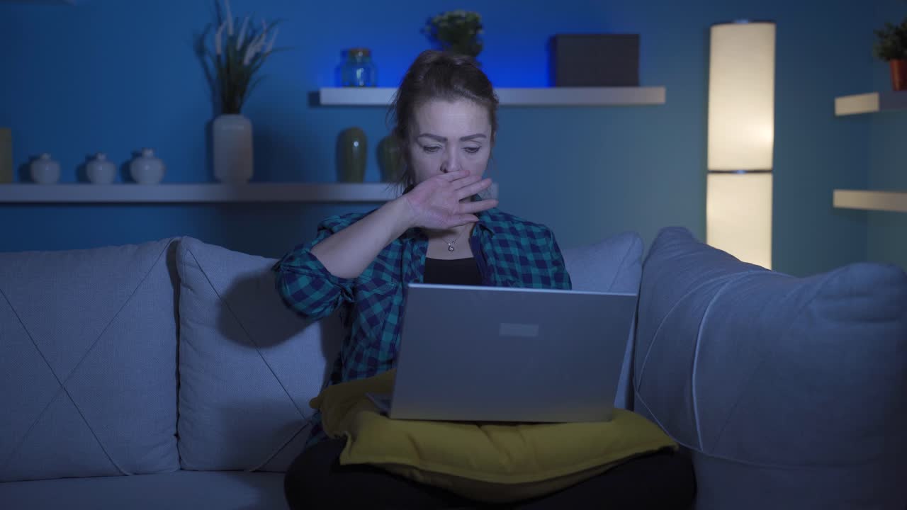 mujer buscando cansado y agotado en la computadora portátil por la noche.