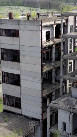 damaged industry. abandoned place with old unfinished buildings of a factory. old industrial plant in springtime. drone view. vertical video