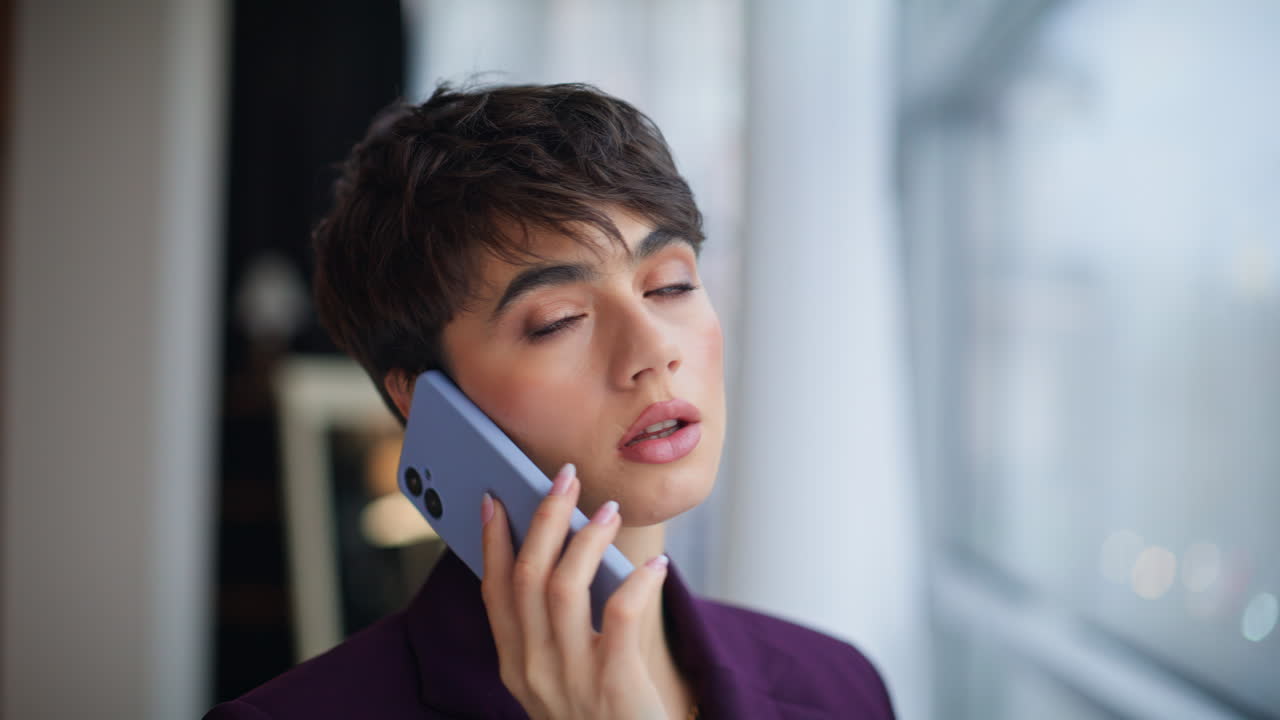 Business manager speaking cellphone looking panoramic window office closeup