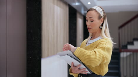 a businesswoman with documents in an office hallway