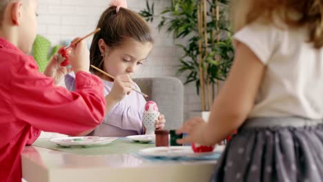 grupo de niños pintando huevos de pascua