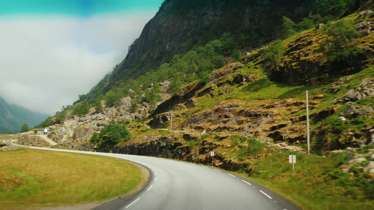 노르웨이 1인칭 시점의 산들 사이의 경치 좋은 길을 따라 가다