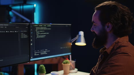 smiling freelancing developer in home office doing coding on computer