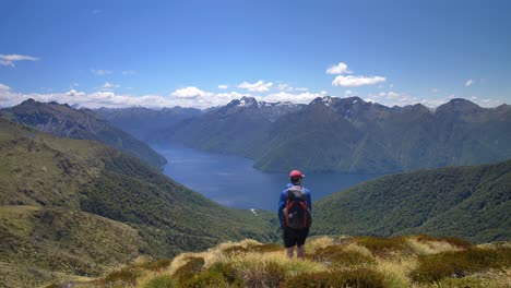 caminante estático, con vistas al paisaje del lago rodeado de montañas, kepler track nueva zelanda