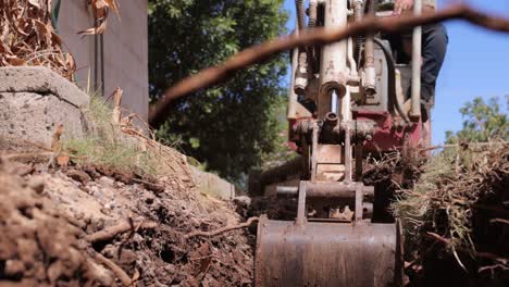 Hand-held-Footage-Of-A-Man-Using-An-Excavator-To-Remove-Dirt-Out-Of-The-Hole