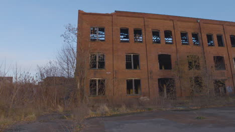 an abandoned red brick industrial building against a blue sky in northeast ohio