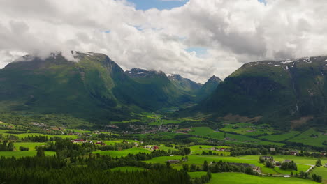 Campo-Verde-Con-Nubes-Blancas-En-La-Cima-De-Las-Montañas,-Byrkjelo-Noruega