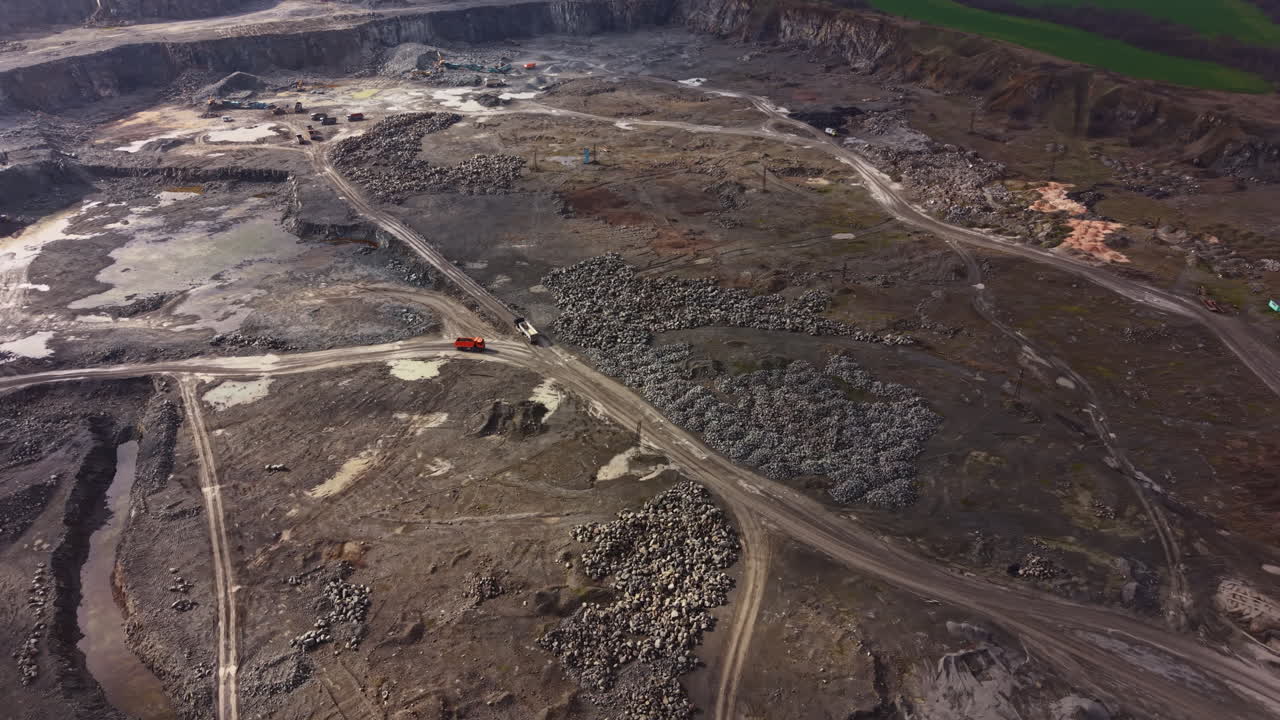 Granite quarry shows workers and machinery at work in a large open pit during daylight in a rural area with rich natural features