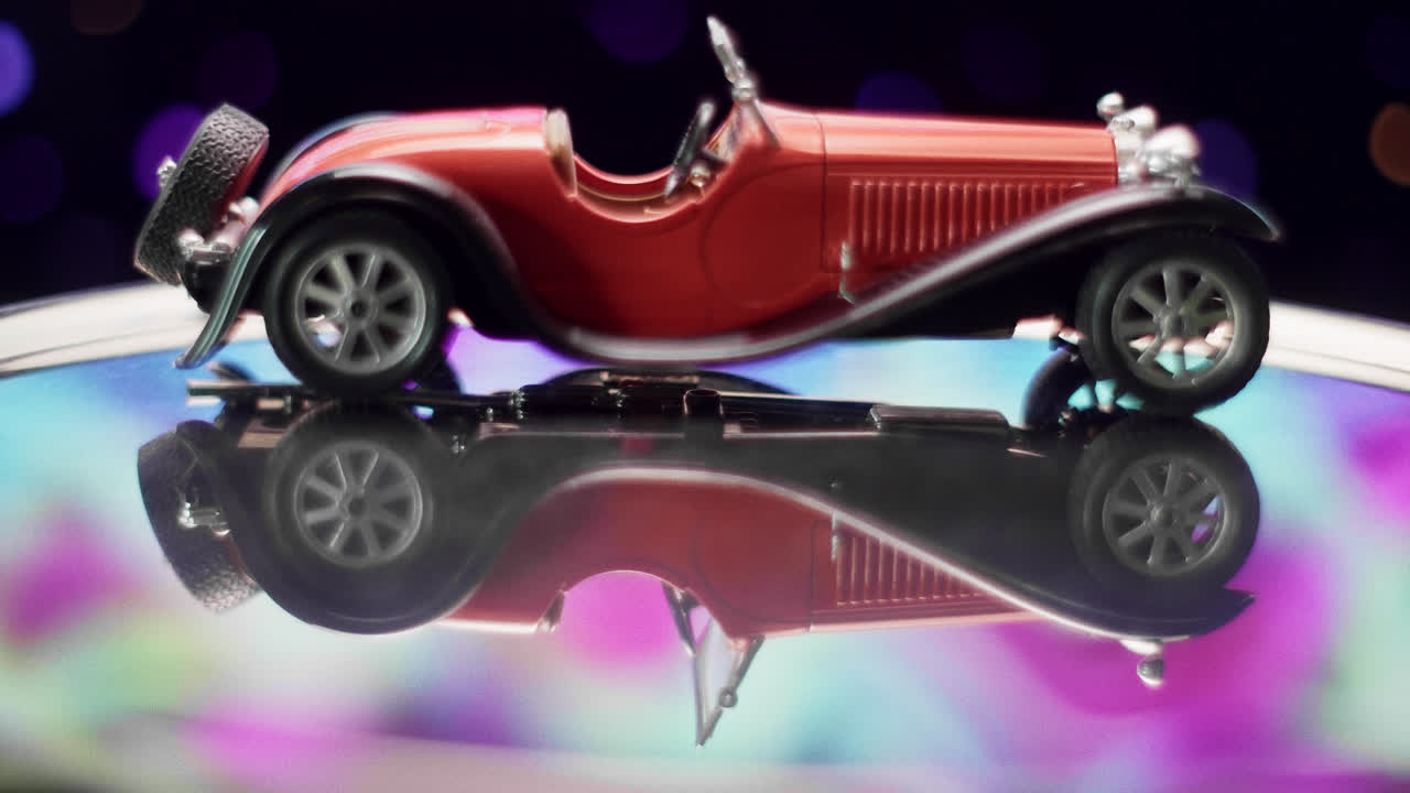 Red Vintage Model Car with Reflection and Bokeh Lights