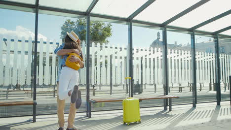 Happy-Caucasian-young-couple-meeting-at-train-station-and-hugging-on-nice-summer-day