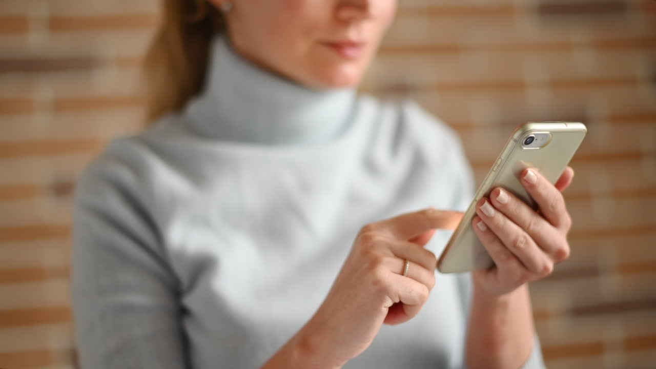 Woman working on mobile phone and writing at the office