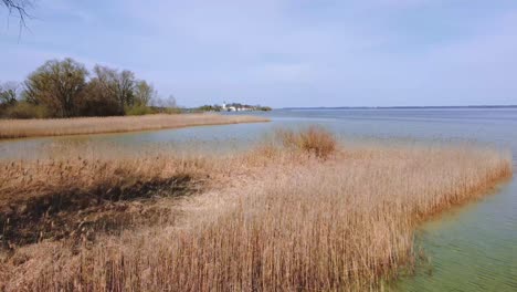 malerischer tiefflug über bayerns berühmtestem chiemsee in ländlicher umgebung mit wunderschönem himmel, klarem blauen wasser und der idyllischen fraueninsel im hintergrund an einem sonnigen tag