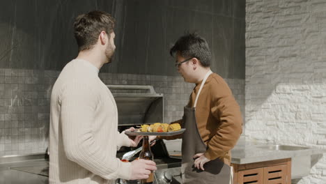 a young guy and his friend talking while having a barbecue 1