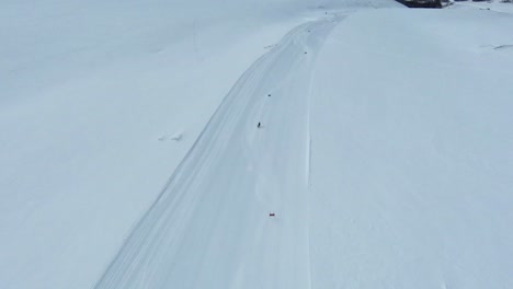 High-angle-aerial-tracking-follows-elite-skier-slalom-racing-across-fresh-groomed-run
