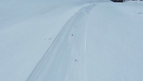 high angle aerial tracking follows elite skier slalom racing across fresh groomed run