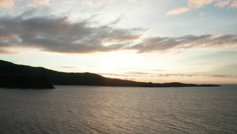 amanecer dorado observado junto con las aguas tranquilas y la silueta de la isla naviti, toma amplia