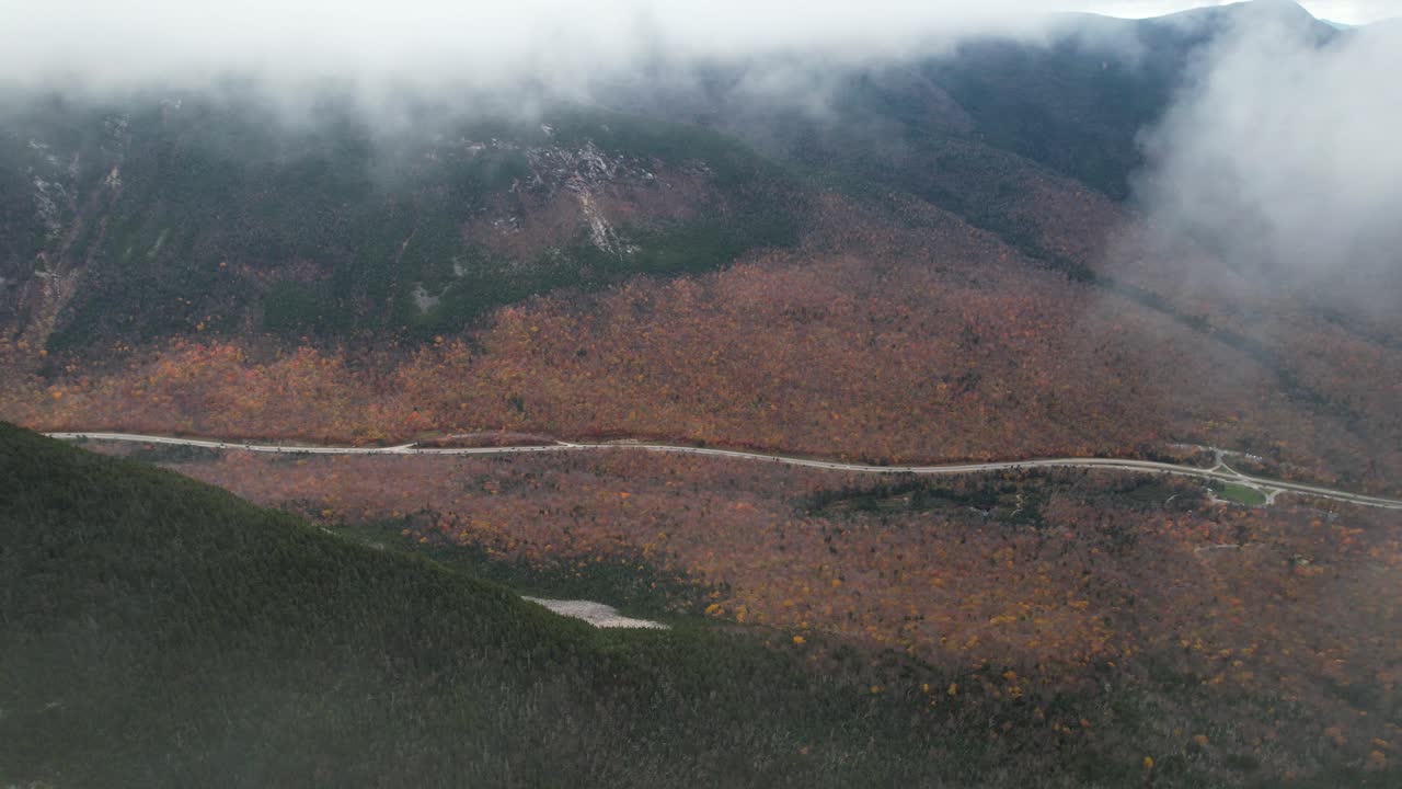 구름과 풍경 위로 날아가는 가파른 언덕 아래 계곡에 있는 미국 산길의 고층 조감도