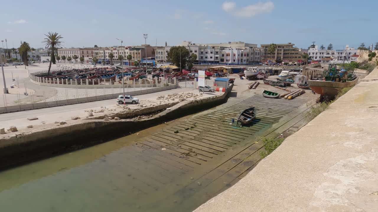 Carrellata di uno scivolo per imbarcazioni nell'oceano vicino alla fortezza di Mazagan.