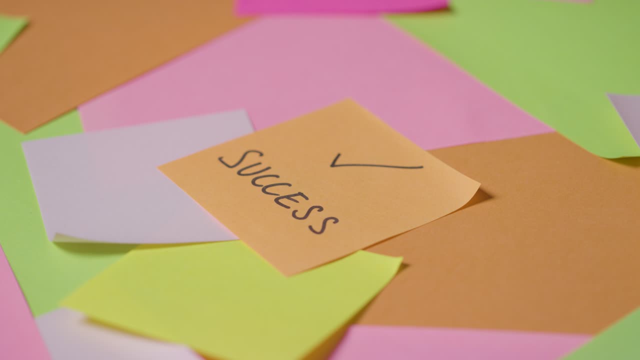탑 노트 1에 쓰여진 성공과 함께 회전하는 스티커 메모의 비즈니스 개념