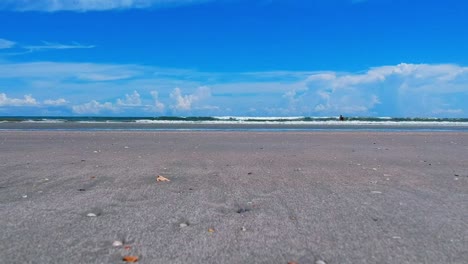 serene beach day: blue sky, calm waves, and sandy shores