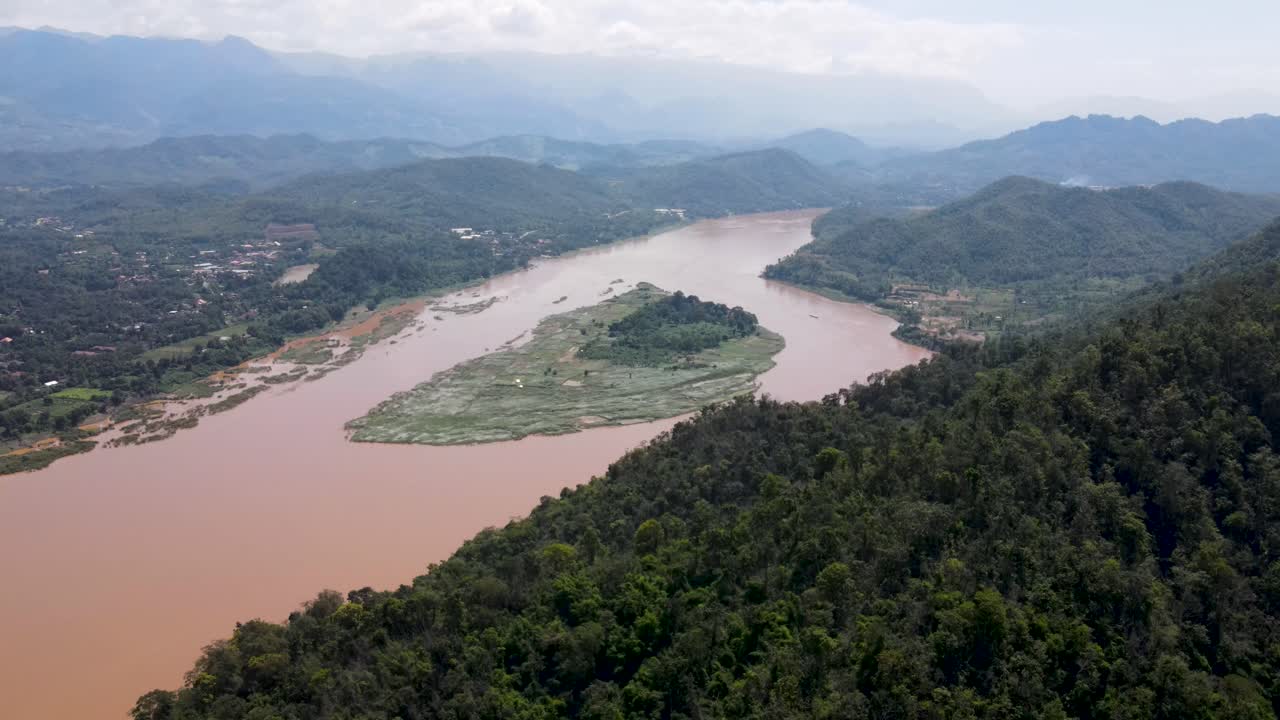 Volo aereo su una collina con foresta tropicale con vista sul fiume Mekong