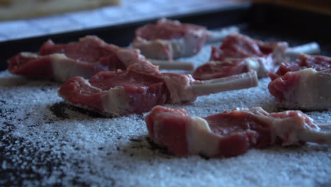 carne de envejecimiento en seco, chef que prepara chuletas de cordero para el envejecimiento en seco, proceso de salazón