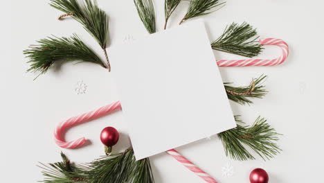 video of christmas decorations with card and copy space on white background