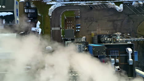 fumée blanche se déplaçant sur un site industriel avec des ventilateurs rotatifs