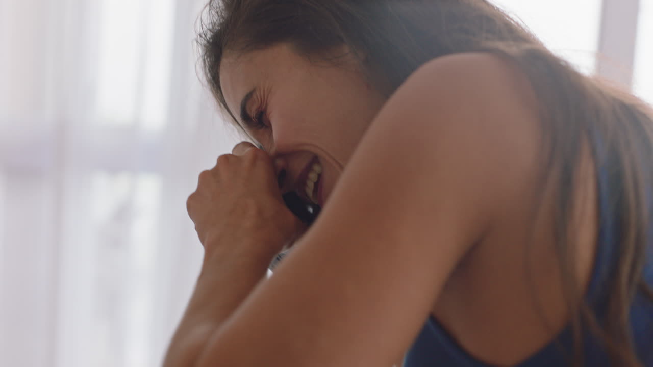 happy couple taking photos together using camera having fun at home on bed playfully enjoying romantic relationship photographing each other