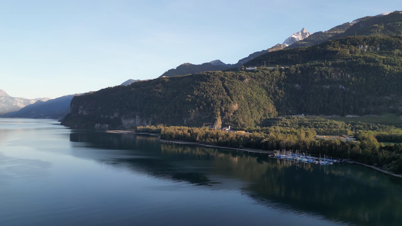 세일보트 가 있는 작은 마리나 가 월렌시 호수 의 반 ⁇ 이는 파란 물 에 앉아 있다