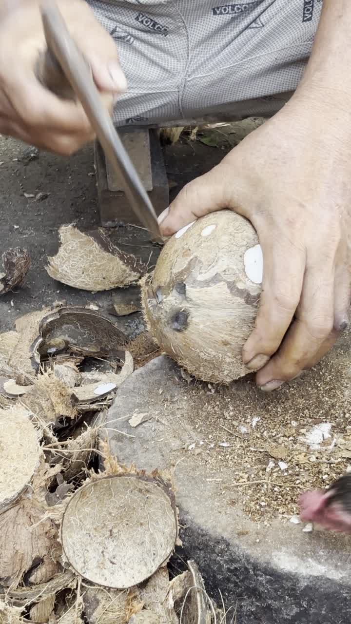 Detail rukou loupajících čerstvý kokos nožem