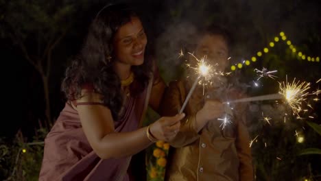 diwali celebrating a family family bursting firecrackers in diwali festival in india, mother and child enjoying with firecrackers
