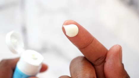 applying cream or lotion to finger