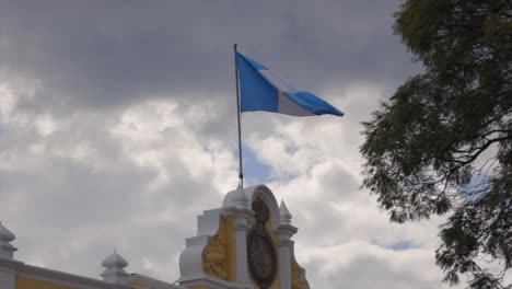 guatemala national flag blue white stripes top of building waving central america