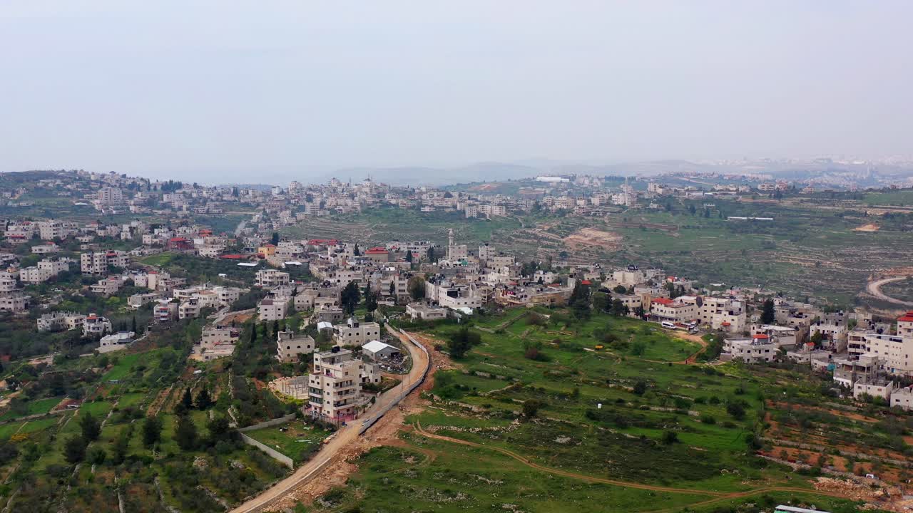 Aerial view of a Middle Eastern town or village nestled in green hills