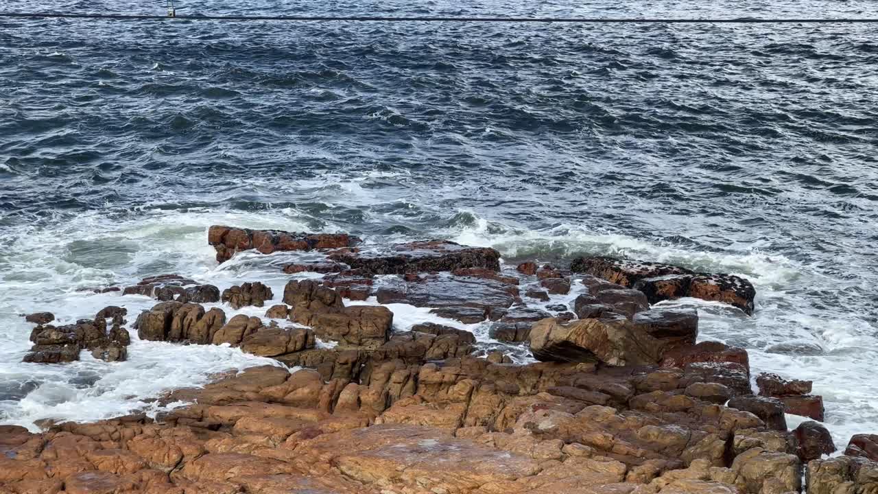 The waves hitting some rocks near Fish Hoek in Cape Town, South Africa.