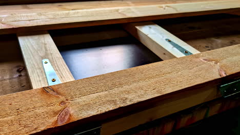 Wooden door under construction with frame, planks and metal hinges during build