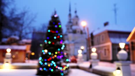 new year boke lights xmas christmas tree decoration and orthodox church in background. festive illumination, natural defocused blue bokeh background effect