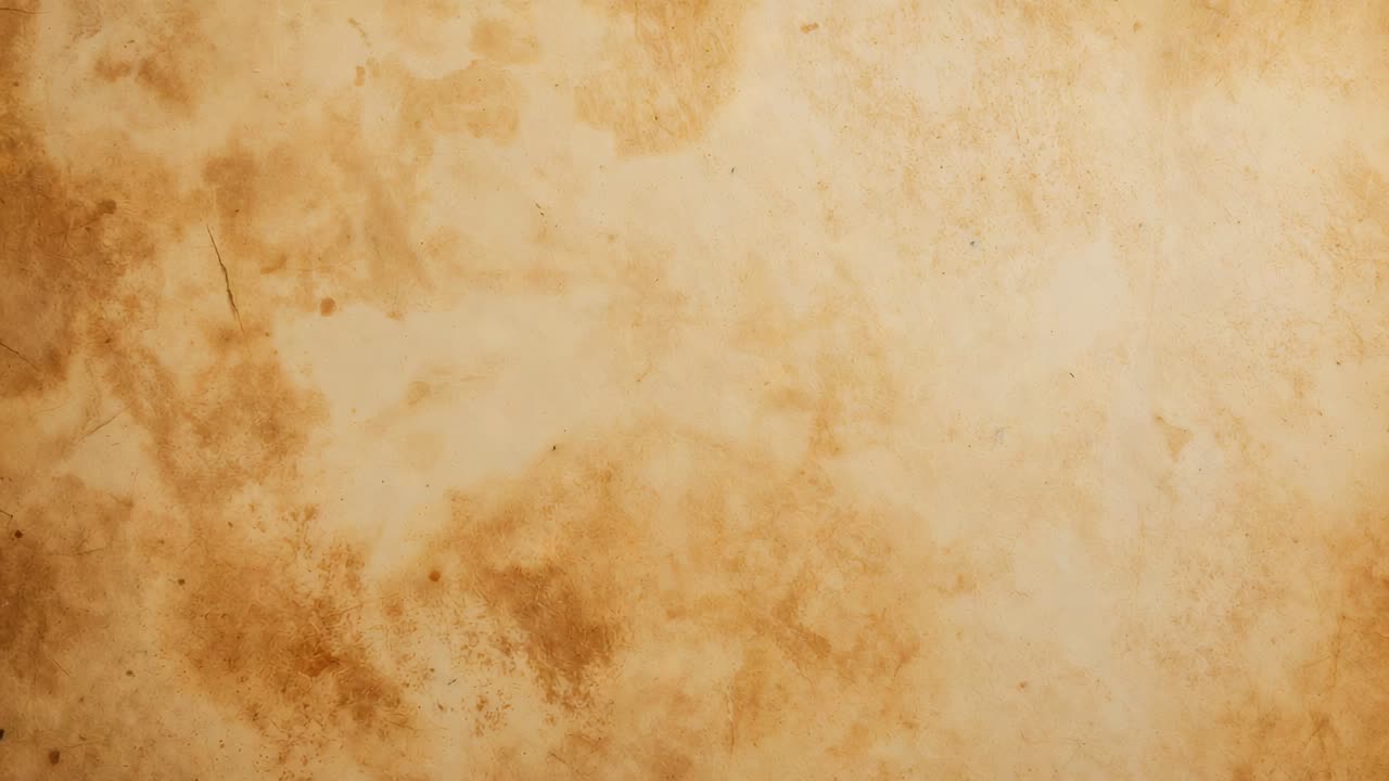 Operator adjusting framing, camera panning right and down at table, revealing aged parchment