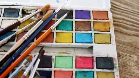 Various-paint-brushes-on-wooden-table